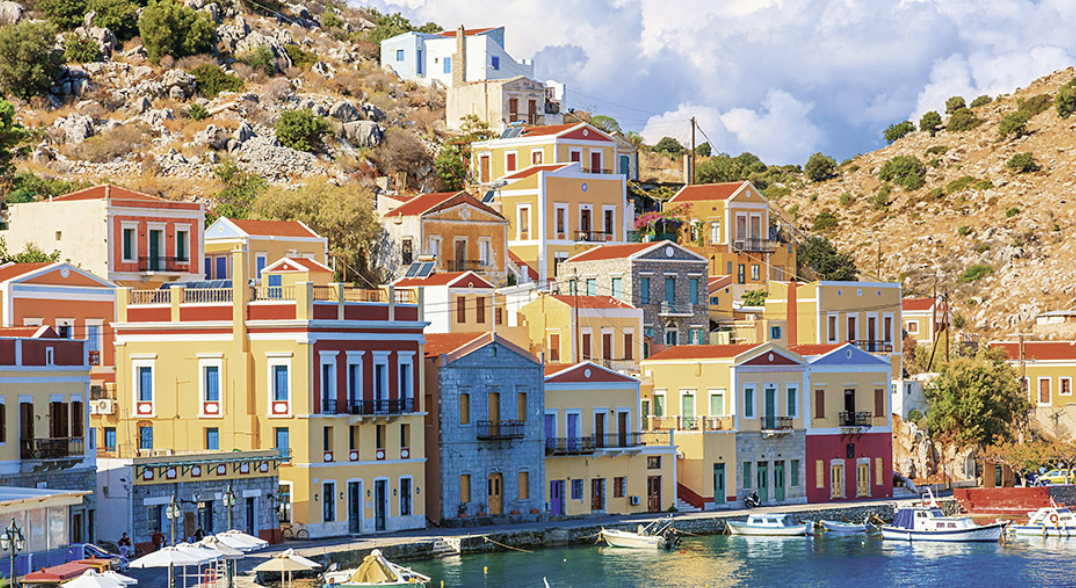 Neoclassical façades of a Dodecanese harbour seen from a yacht coming in